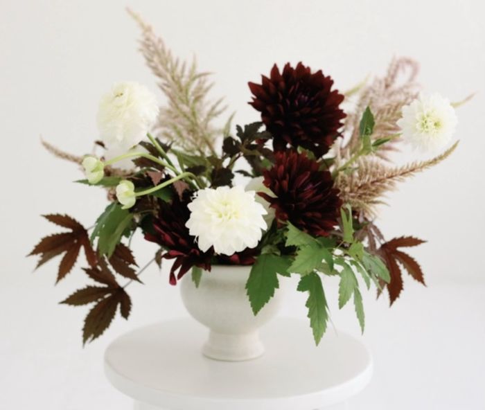 Deep burgundy dahlias with white blooms and grasses