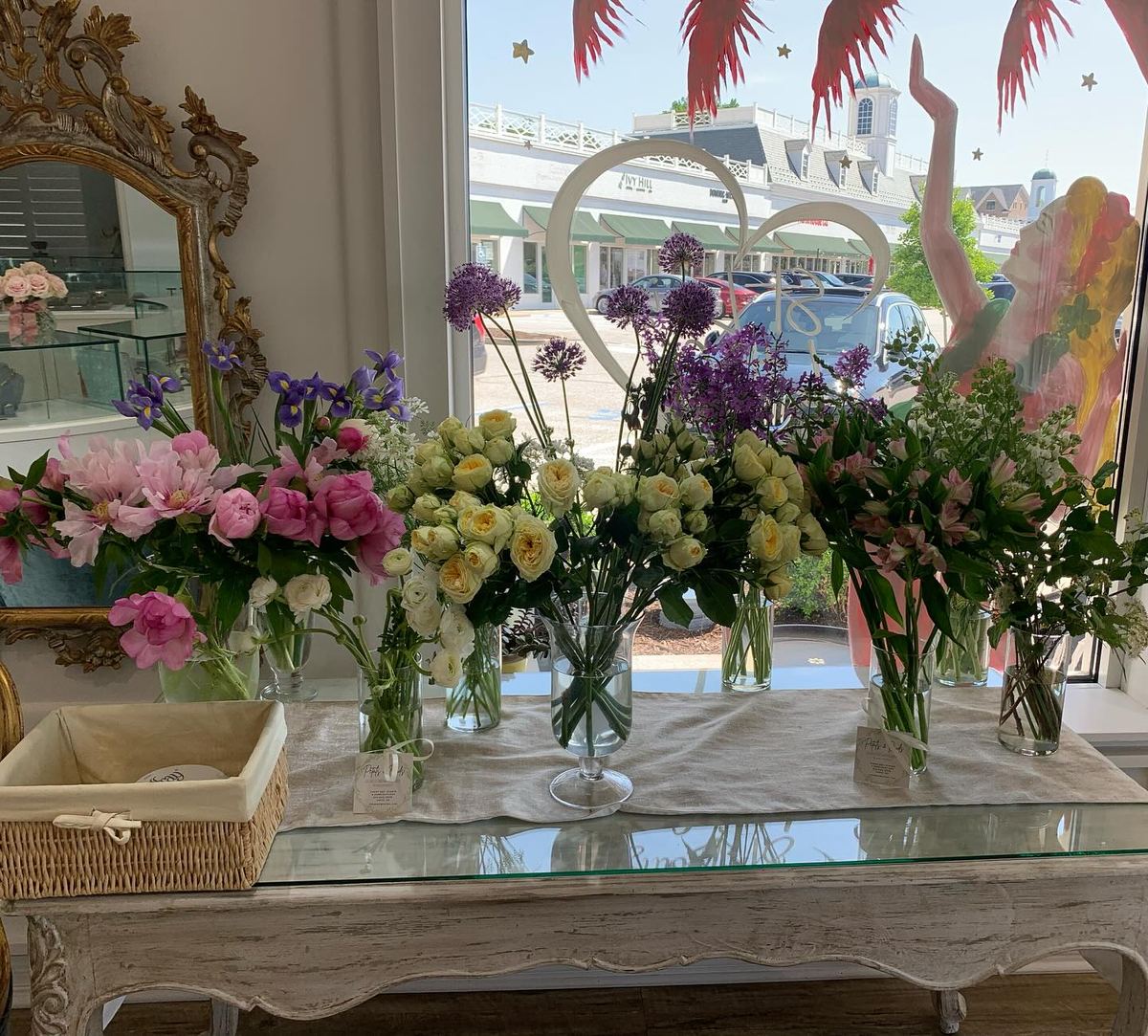 A table lined with bud vases and buckets of flowers
